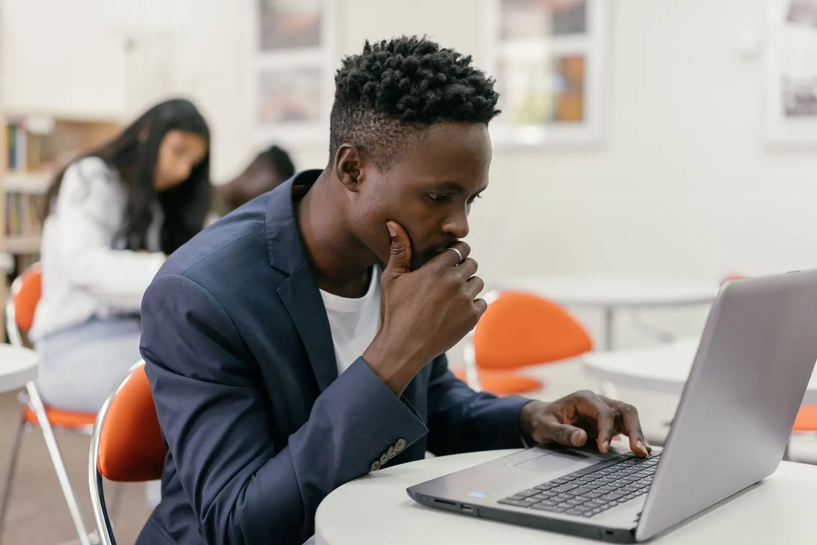 Business owner reading on his laptop, hand on his chin