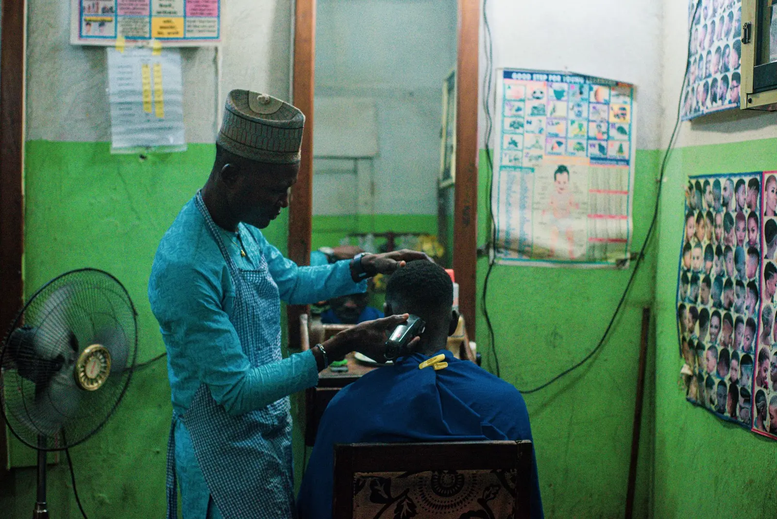 Barber at work in a busy Kenyan barbershop